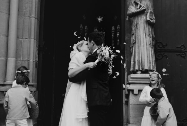 Photo noir & blanc des mariés qui s'embrassent devant l'église Saint-André de Bayonne