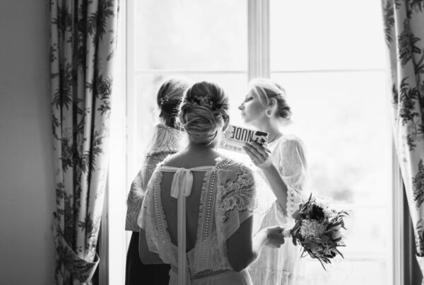 Préparatifs de la mariée qui regarde sa mère et sa soeur se maquiller