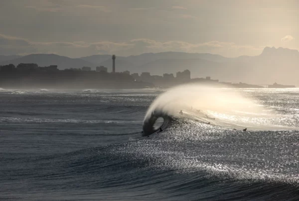 Tube dans une vague à Anglet avec le phare de Biarritz en fond