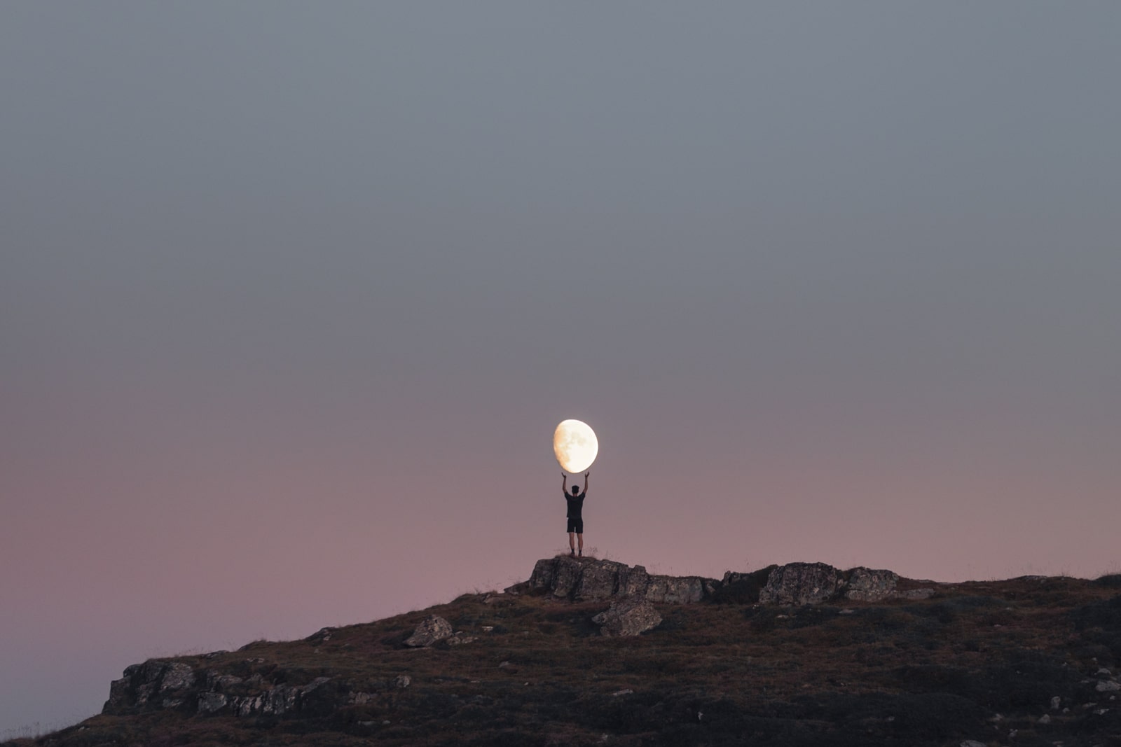 La lune portée par un sujet sur une montagne