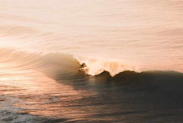 Surfeur au coucher du soleil qui est dans la vague